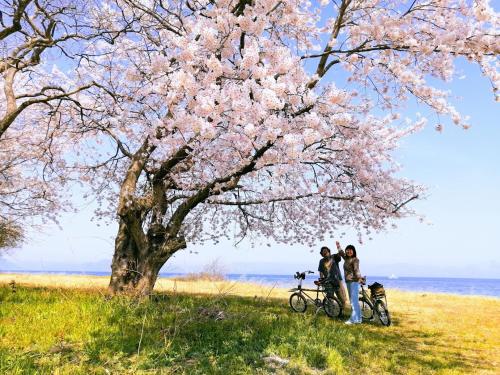 高岛市静かに過ごす室内テント Staying quietly indoor tent的两个人骑着自行车站在树下