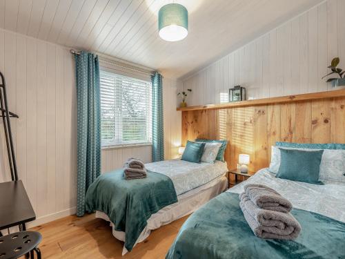 WillingtonHeather Lodge的一间卧室设有两张床和窗户。