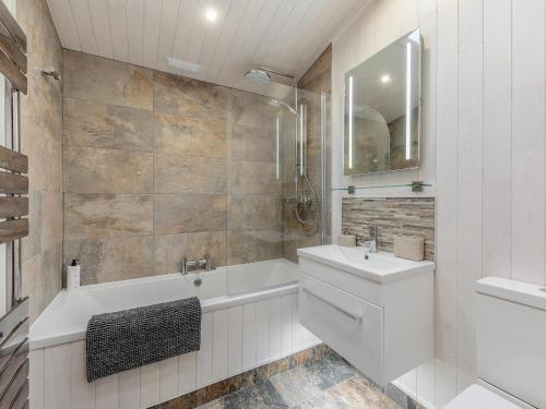 WillingtonHeather Lodge的白色的浴室设有浴缸和水槽。
