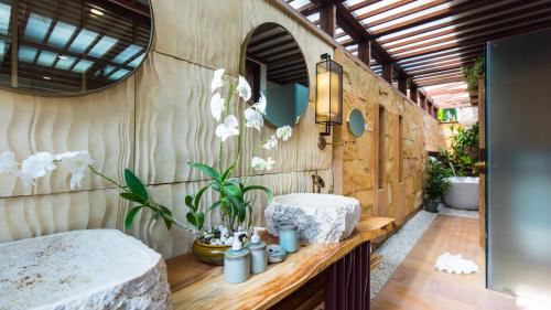 利巴诺伊Baan Tao Talay - Beachfront Private Villa的浴室设有水槽和鲜花台面