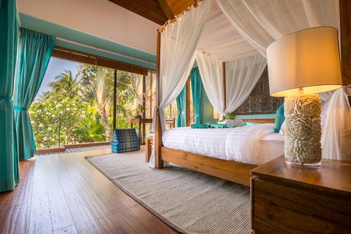 利巴诺伊Baan Tao Talay - Beachfront Private Villa的一间卧室设有一张床和一个大窗户