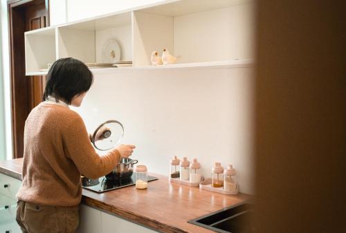 Thôn Dương Xuân HạL'âme - The Hideaway的站在厨房里准备搅拌机食物的女人