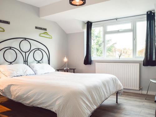 埃文河畔斯特拉特福Sidelands Sojourn的卧室设有一张白色大床和一扇窗户。