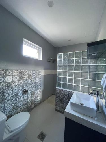 邦劳Bella Napoli Resort & Resto的浴室配有白色卫生间和盥洗盆。