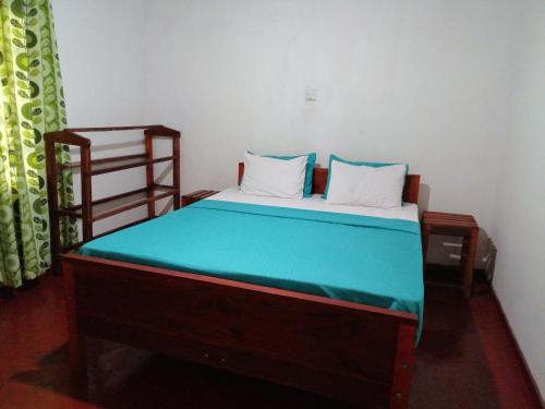 代尼耶耶Traveller's Choice Sinharaja的小卧室配有一张带蓝色床罩的床