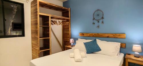 爱妮岛Calao Villa, Solar Villa 2 rooms with Private Pool的卧室配有白色的床和蓝色的墙壁