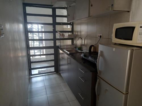 内罗毕Oasis comfort的厨房配有白色冰箱和微波炉