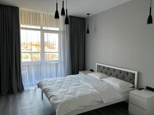 利沃夫EAvalonRestApartment的白色的卧室设有一张大床和一个窗户