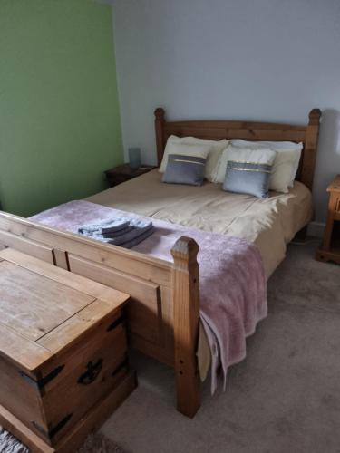 AuchtermuchtyCameron House - spacious B listed building, near Falkland, Central East Scotland的一间卧室配有一张带两个枕头的大木床