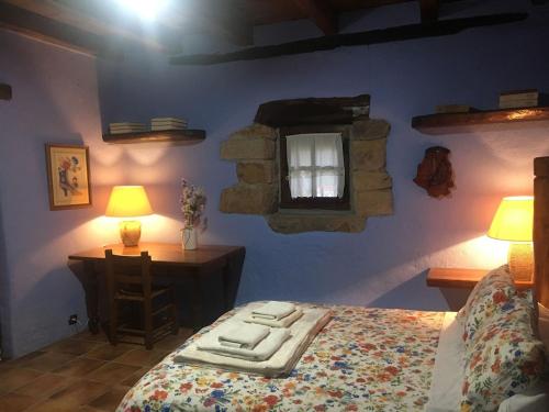 巴基奥Precioso caserío con jardín的一间卧室配有一张床、一张桌子和一个窗户。