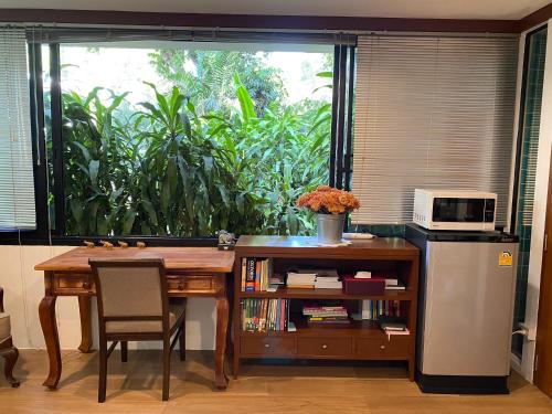 曼谷Cozycomo Bangkok的厨房配有桌子、微波炉和窗户