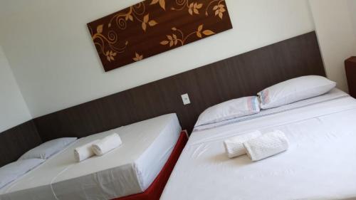 巴雷里尼亚斯Apartamento em Resort的配有2张床的带白色床单和枕头的客房
