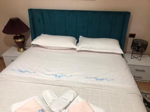 吉诺卡斯特Alva Room's的一张带蓝色床头板和两双白鞋的床