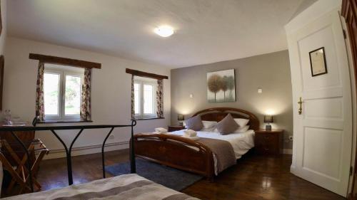 托尔明Hisa Brdo Guesthouse的一间卧室配有一张床、一张书桌和两个窗户。