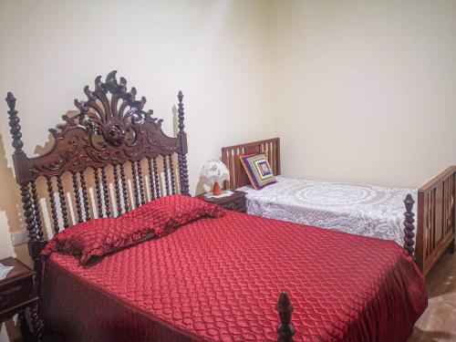 Santana de CambasCasa do Rosa - Santana de Cambas的一间卧室配有一张红色棉被的床