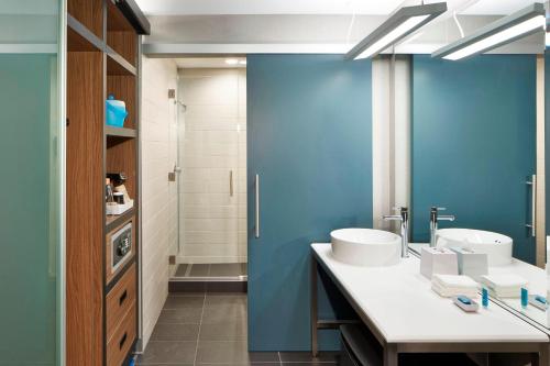 雷德蒙德西雅图雷德蒙德雅乐轩酒店的浴室设有两个水槽和蓝色的墙壁。