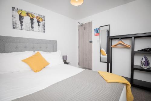 大雅茅斯Self containted 1 Bed modern apartment- Meters from Beach的卧室配有白色床和橙色枕头