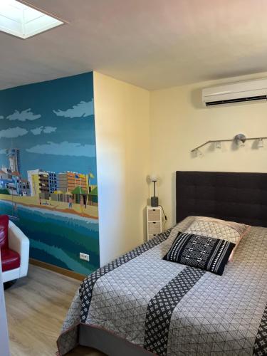 帕拉瓦莱弗洛appartement atypique en duplex的卧室配有一张床,墙上挂有绘画作品