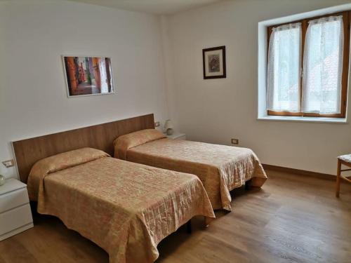 ValdaVerde di Valda的酒店客房设有两张床和窗户。