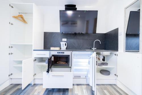 克利索普斯Hillcrest Studio Apartments的厨房配有白色橱柜和水槽