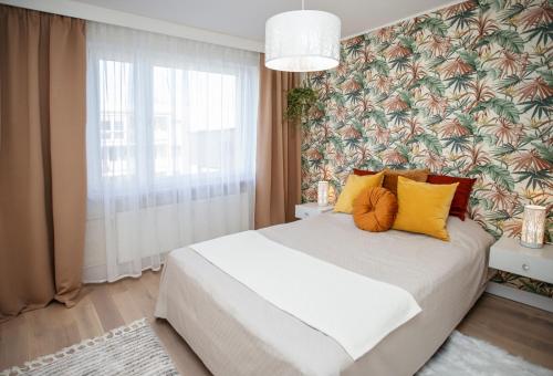 索波特Apartament Sopot Kamienny Potok Kujawska的一间卧室配有黄色和橙色枕头的床