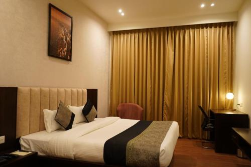 Pura RaghunāthHOTEL DHAROHAR的酒店客房设有床和窗户。