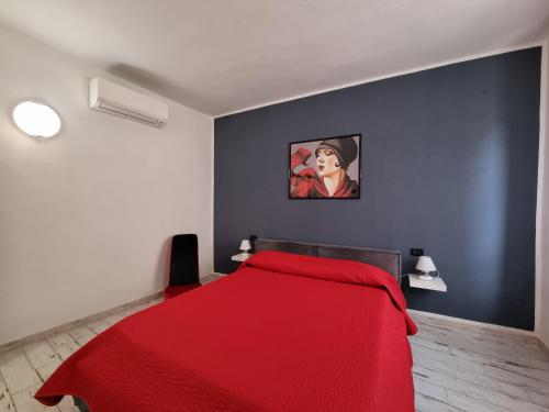 卡波利韦里Solino House的卧室配有红色的床,墙上挂有绘画作品