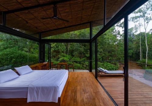 KalawanaKurunduketiya Private Rainforest Resort的一间卧室,在木甲板上配有一张床