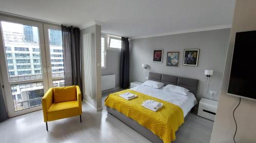 华沙Elegancki apartament w sercu Warszawy的一间卧室配有黄色的床和黄色的椅子