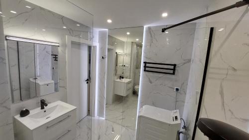 华沙Elegancki apartament w sercu Warszawy的带淋浴和盥洗盆的白色浴室