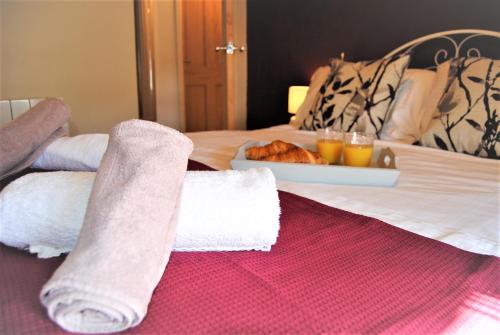 朗日Snowdon Cottage 2的一张带两条毛巾和一盘食物的床