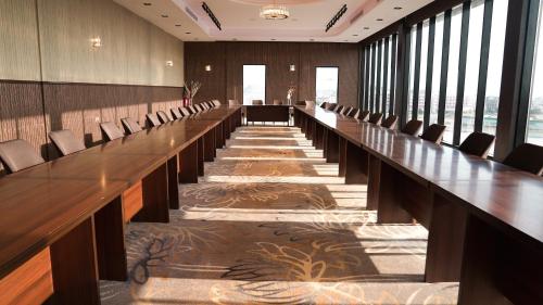 吉赞فندق سنبات بلاتينيوم的大型会议室,配有长桌子和椅子