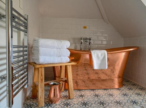 圣艾夫斯霍威尔旅舍的浴室设有木制浴缸和毛巾