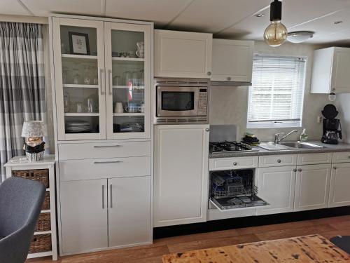 BaarlandChalet - Dà gae nog à的厨房配有白色橱柜和微波炉