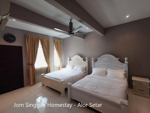 阿罗士打Jom Singgah Homestay - Alor Setar的一间卧室配有两张床和吊扇