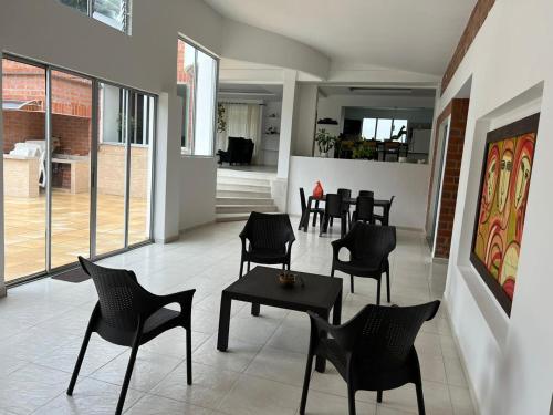 拉特瓦伊达Casa Campestre Sol Naciente的一间餐厅,房间内设有黑椅子和桌子