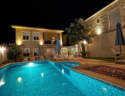 莫斯塔尔Apartments Villa Mike的夜间在房子前面的游泳池