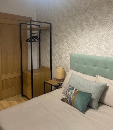 萨莫拉Apartamento casco histórico的一间卧室配有一张白色的床和蓝色床头板