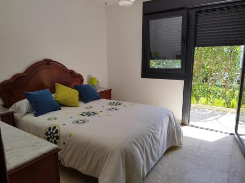 格罗韦JARDIN, TERRAZA Y BARBACOA的一间卧室配有蓝色和黄色枕头的床