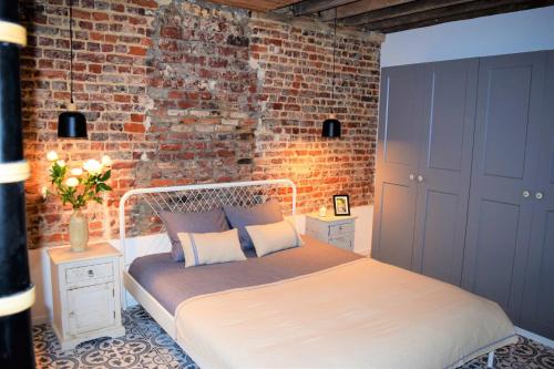 布鲁塞尔Home Sweet Home Brussels center的一间卧室配有一张砖墙床