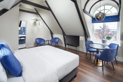 MiddenbeemsterBoutique Hotel Brasa Beemster的卧室配有一张床和一张桌子及椅子