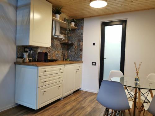 巴洛泰什蒂Kopel Haus - Studio - Self acces cod location的厨房配有白色橱柜和玻璃桌