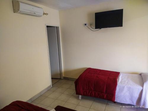 萨尔塔德拉琳达酒店的一间设有床铺和墙上电视的客房
