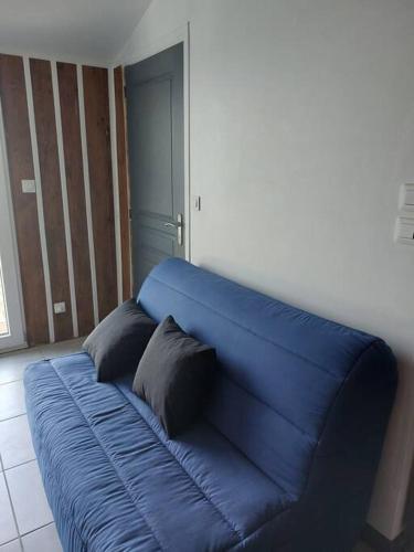 拉蒙塔涅Studio 4 personnes的蓝色的沙发,房间上有两个枕头
