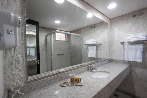 库里提巴麻布库里提巴商务酒店的一间带水槽和镜子的浴室