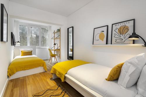 埃斯托利尔WHome Chic & Stylish Retreat in Estoril's Finest Location的白色卧室配有床和黄色毯子
