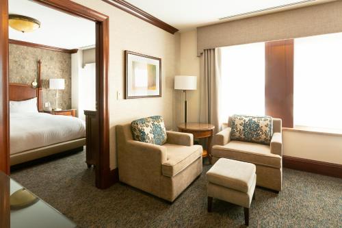 罗切斯特卡乐格兰德塔尔酒店的酒店客房,配有一张床和两把椅子