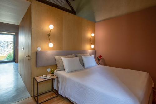 蓬塔德尔加达Green&Houses的卧室配有一张白色大床和一张边桌