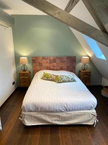 萨维尔纳La Mezzanine des Rohan Saverne的一间卧室配有一张大床和两盏灯。