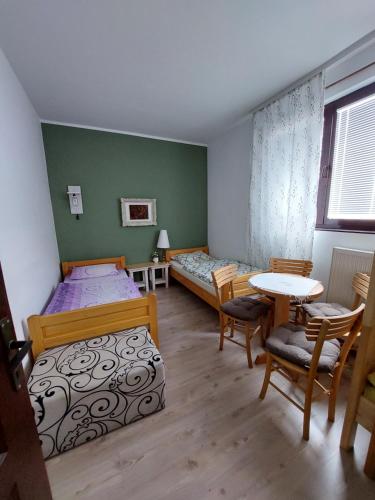 斯梅代雷沃HostelChe Guest House的一间卧室配有两张床和一张桌子及椅子